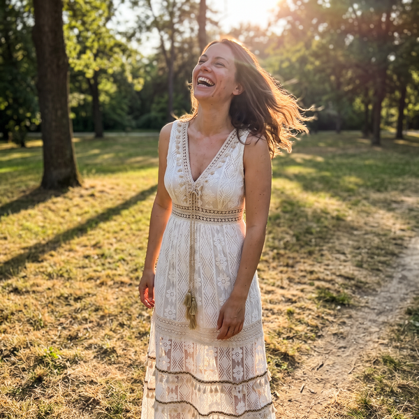 White-beige boho lace crochet maxi dress in a park
